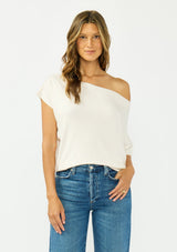 [Color: Natural] A front facing image a brunette model wearing an off white off the shoulder sweater top with short sleeves and a fitted ribbed hem. 