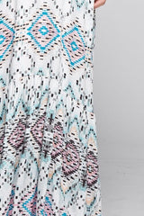 [Color: Black/Aqua/Multi] A detail image of a brunette model wearing bohemian maxi dress with a blue geometric print, spaghetti straps, and a racerback with tassel ties. 
