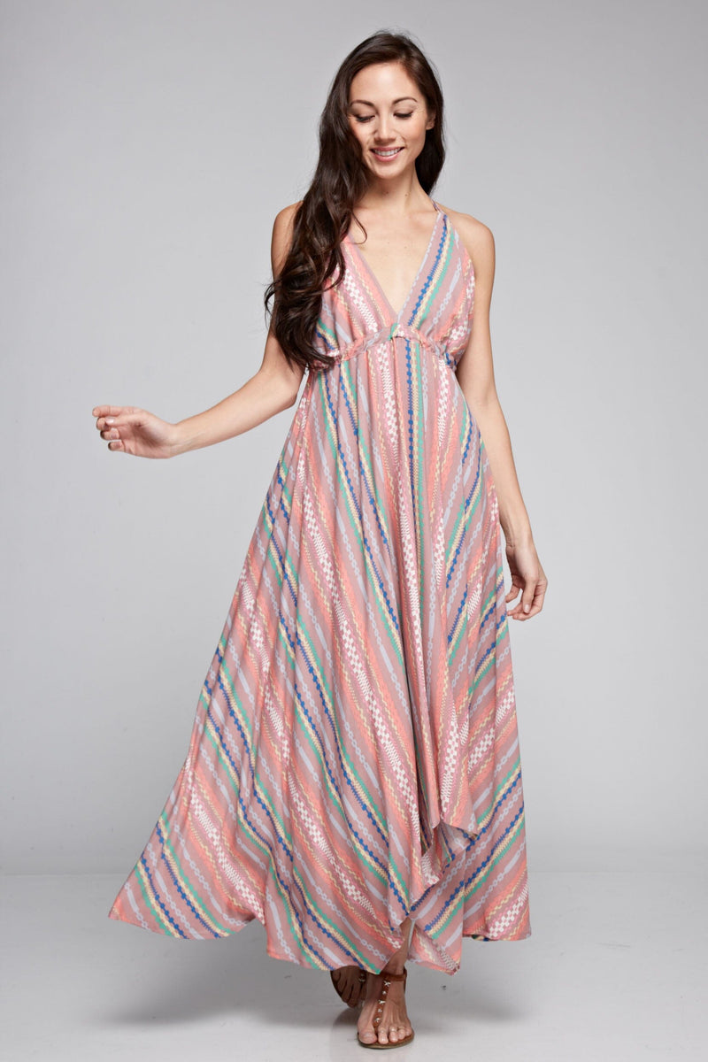 [Color: Brick Multi] A brunette model wearing a boho striped geo print halter maxi dress with a flowy shark bite skirt, open back, and a flattering v-neckline. 