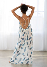 [Color: Blue/Ivory] A back facing image of a brunette model wearing a sheer blue and white pineapple print maxi dress with a scoop neckline and adjustable spaghetti straps, and strappy back design.