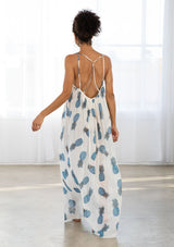 [Color: Blue/Ivory] A back facing image of a brunette model wearing a sheer blue and white pineapple print maxi dress with a scoop neckline and adjustable spaghetti straps, and strappy back design.