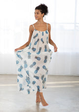 [Color: Blue/Ivory] A front facing image of a brunette model wearing a sheer blue and white pineapple print maxi dress with a scoop neckline and adjustable spaghetti straps, and strappy back design.