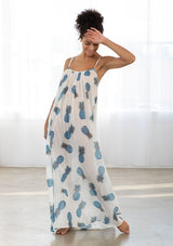 [Color: Blue/Ivory] A front facing image of a brunette model wearing a sheer blue and white pineapple print maxi dress with a scoop neckline and adjustable spaghetti straps, and strappy back design.