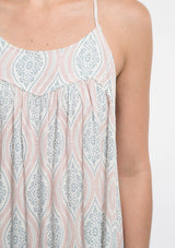 [Color: Nude Combo] A detail image of a blonde model  wearing a bohemian maxi dress with a halter neckline and a racerback with tassel tie detail. 