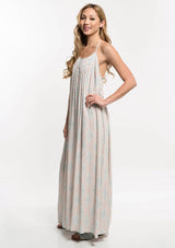 [Color: Nude Combo] A side facing image of a blonde model  wearing a bohemian maxi dress with a halter neckline and a racerback with tassel ties.