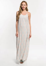 [Color: Nude Combo] A front facing image of a blonde model  wearing a bohemian maxi dress with a halter neckline and a racerback with tassel ties.