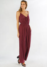 [Color: Burgundy] A front facing image of a woman wearing a one piece jumpsuit. Featuring a wide leg, a front keyhole detail, an elastic cinched waist, and side pockets.