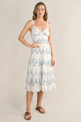 [Color: White/Blue] A front facing image of a blonde model wearing a white and blue chevron pattern midi dress with all over eyelet details. Featuring a sleeveless design, a v-neckline, smocked back, button front top, and flowy tiered skirt. 