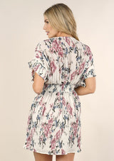 [Color: Ivory Orchid] A back facing image of a blonde model wearing a pink and blue floral print mini dress with a button front top, short dolman sleeves, and a smocked waistline. 