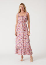 [Color: Dusty Purple/Taupe] A front facing image of a blonde model wearing a pink and purple floral print maxi dress. With ruffled tank top straps, a ruffle trimmed square neckline, an elastic waist, a tiered long skirt, and a lace up top. 