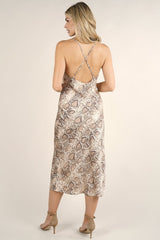 [Color: Ivory Mocha] A front facing image of a blonde model wearing brown  snake print midi dress  with a cowl neckline and cross back. 