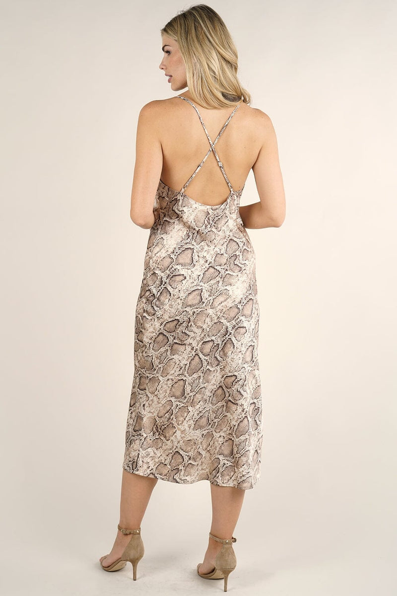 [Color: Ivory Mocha] A front facing image of a blonde model wearing brown  snake print midi dress  with a cowl neckline and cross back. 