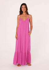 [Color: Purple] A front facing image of a brunette model wearing a simple flowy sleeveless maxi tank dress in a bright purple crinkle rayon. With a v neckline in front and back, adjustable spaghetti straps, and a tiered skirt.