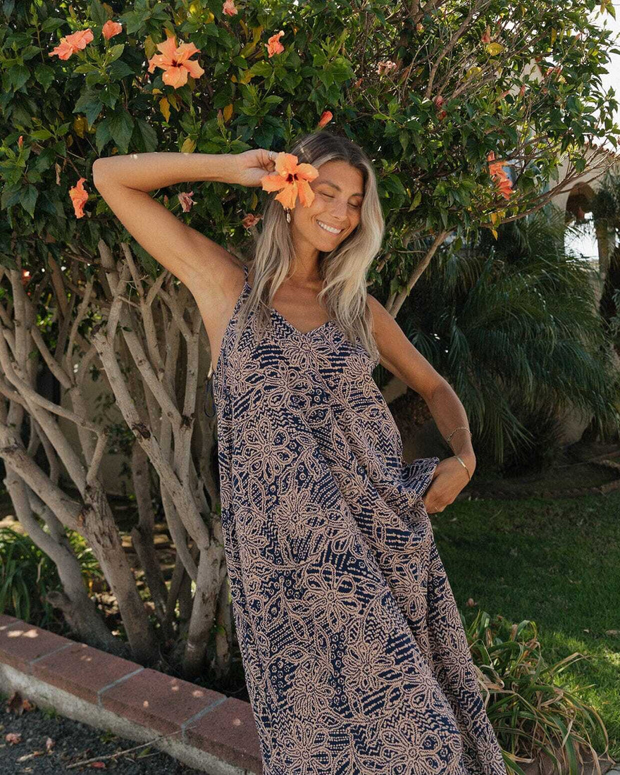 Woman in a patterned dress standing outdoors with flowers in her hair