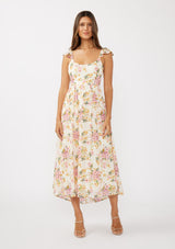 [Color: Natural/Dusty Pink] A front facing image of a brunette model in an off-white and pink floral maxi dress featuring flutter cap sleeves, a scoop neckline, an open back with tie detail, and a fit-and-flare silhouette. Ideal for Easter or special occasions.