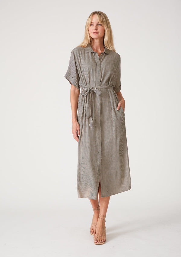 [Color: Taupe/Navy] A front facing image of a blonde model wearing a relaxed fit mid length shirt dress in a taupe and navy blue stripe. With short dolman sleeves, a collared neckline, a concealed button front, side pockets, a waist belt, and side slits. 