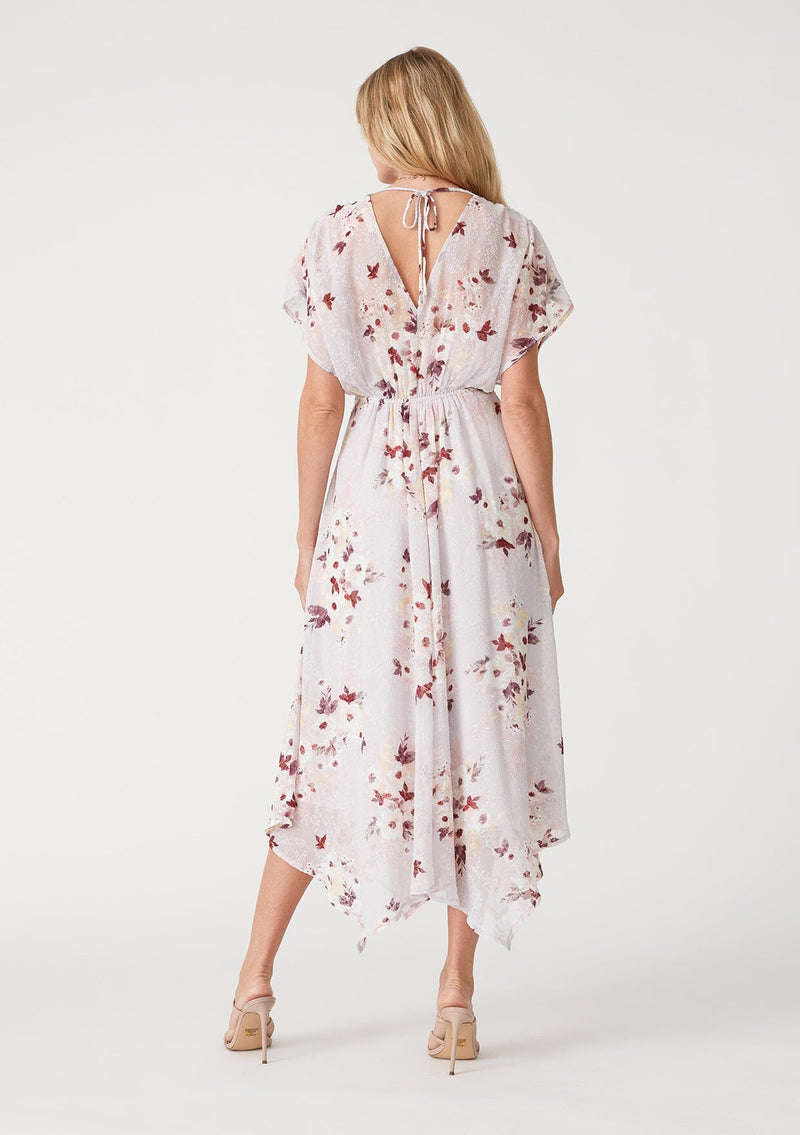 [Color: Dusty Blush/Wine] A back facing image of a blonde model wearing a bohemian maxi dress designed in a pink floral print and crafted from textured chiffon. With short dolman sleeves, a surplice v neckline, an open back with tie closure, and a flowy asymmetric hemline skirt. 