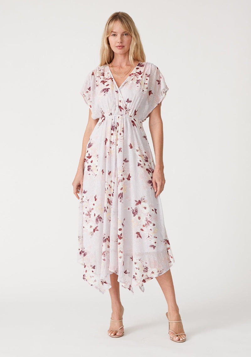 [Color: Dusty Blush/Wine] A front facing image of a blonde model wearing a bohemian maxi dress designed in a pink floral print and crafted from textured chiffon. With short dolman sleeves, a surplice v neckline, an open back with tie closure, and a flowy asymmetric hemline skirt. 