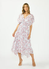 [Color: Grey/Dusty Rose] A front facing image of a brunette model wearing a floral maxi dress with a burnout texture, short dolman sleeves, an asymmetrical hem, and a tie back detail. 