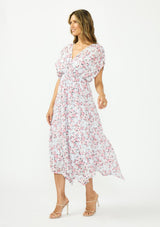 [Color: Grey/Dusty Rose] A side facing image of a brunette model wearing a floral maxi dress with a burnout texture, short dolman sleeves, an asymmetrical hem, and a tie back detail. 