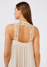 [Color: Natural] A close up back facing image of a brunette model wearing a flowy sleeveless bohemian maxi dress in ivory. With a crochet top, a scooped neckline, and an open back detail. 