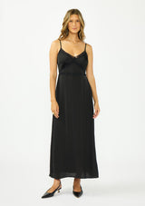 [Color: Black] A front facing image of a brunette model wearing a classic lace trim maxi dress with a v neckline, spaghetti straps, and side slits. 