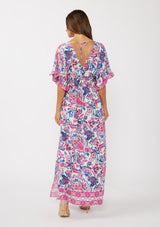 [Color: Natural/Dusty Pink] A back facing image of a brunette model wearing a pink and blue floral print kimono sleeve maxi dress with a ruffle trim, smocked waist, double v-neckline, and side slits. Perfect for spring special occasions. 
