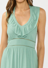 [Color: Navy] A detail  image of a brunette model wearing a flowy green maxi dress with a halter neck, v-neckline, ruffle details, and a tiered skirt. 