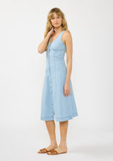 [Color: Light Wash] A side facing image of a blonde model wearing a denim midi dress with a v neckline and button front. 