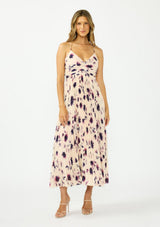 [Color: Peach/Plum] A front facing image of a brunette model wearing a pink and purple floral maxi dress with a pleated design, v neckline, spaghetti straps, and a cross back with tie back detail. 