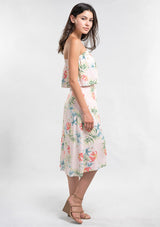 [Color: Blush/Green] A side facing image of a woman modeling a strapless top and matching midi skirt set with a pink and green tropical floral print paired with beige strappy high-heeled sandals.
