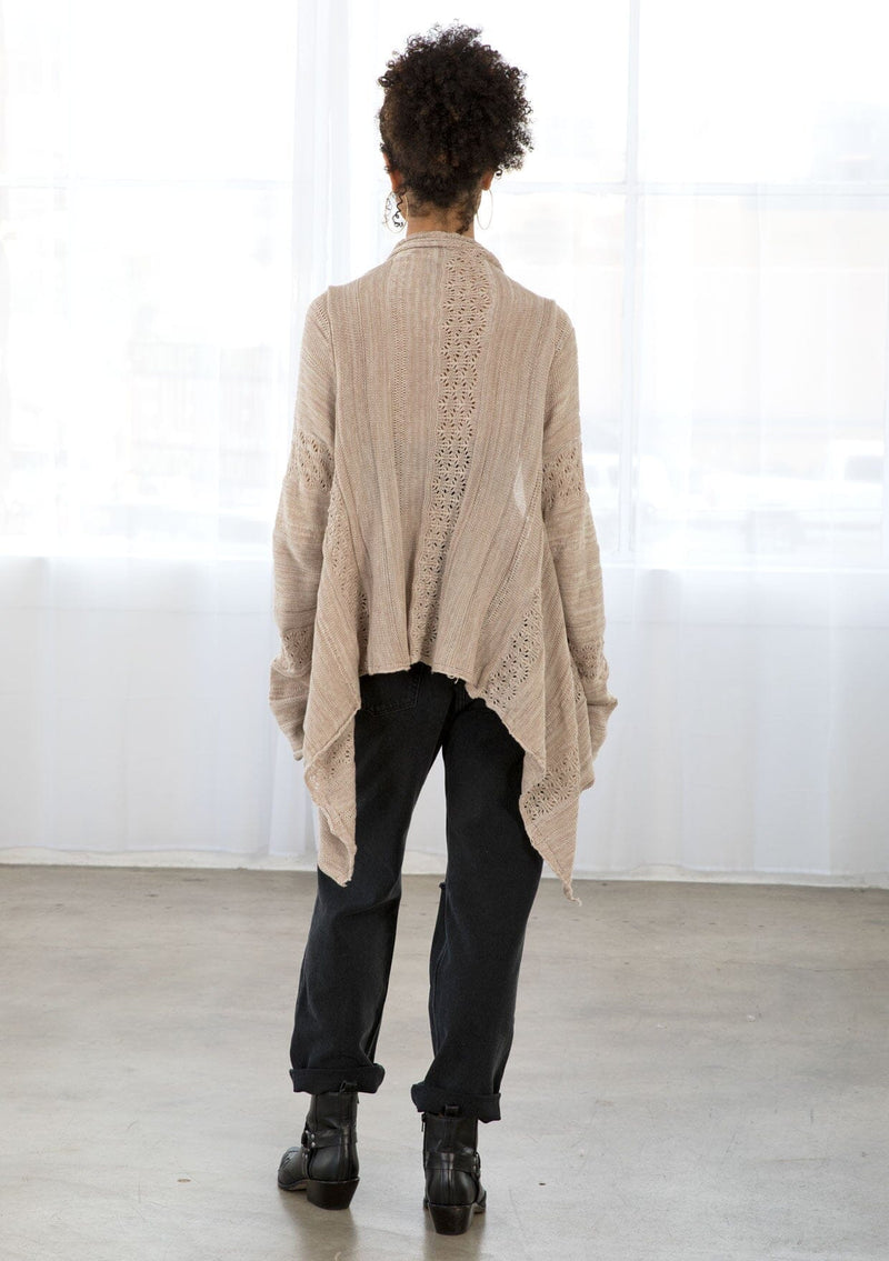 [Color: Pale Mauve] A back facing image of a brunette model wearing a pointelle knit cardigan with metallic thread details, a waterfall front, and long cozy sleeves. 