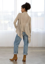 [Color: Warm Grey] A back facing image of a brunette model wearing a pointelle knit cardigan with metallic thread details, a waterfall front, and long cozy sleeves. 