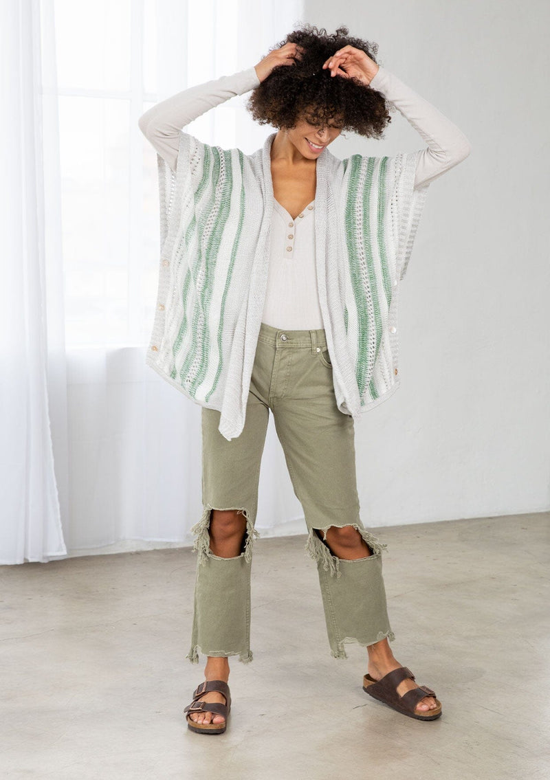 [Color: Silver/Green] A front facing image of a brunette model wearing a lightweight striped cardigan with open knit details, short dolman sleeves, and side button closure. An effortless layer for warm weather days. 