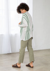 [Color: Silver/Green] A side facing image of a brunette model wearing a lightweight striped cardigan with open knit details, short dolman sleeves, and side button closure. An effortless layer for warm weather days. 