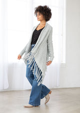 [Color: Grey/Ivory] A front facing image of a marled knit cardigan with a shawl waterfall collar with a fringe hem. A boho chic cardigan for the fall season. 