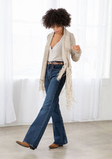 [Color: Natural/Cream] A front facing image of brunette model wearing a marled knit cardigan with a fringe hem, shawl collar, and a cozy, relaxed fit. A versatile fall cardigan. 