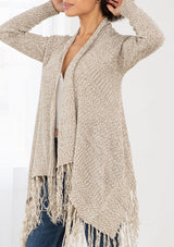 [Color: Natural/Cream] A front facing image of brunette model wearing a marled knit cardigan with a fringe hem, shawl collar, and a cozy, relaxed fit. A versatile fall cardigan. 