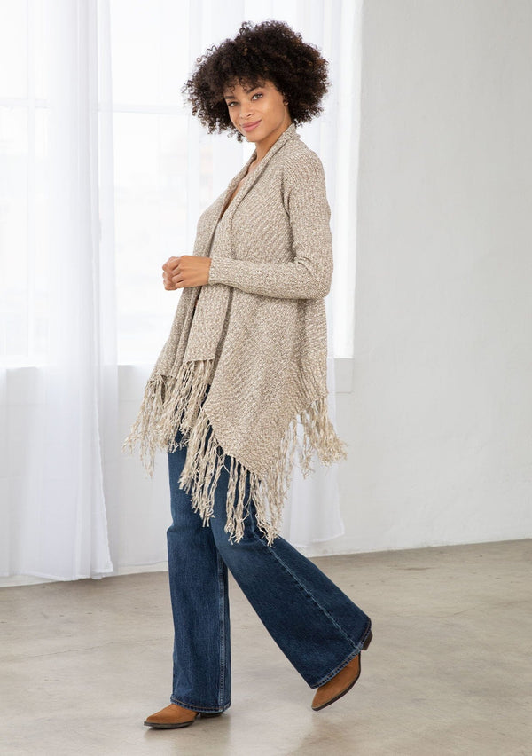 [Color: Natural/Cream] A side facing image of brunette model wearing a marled knit cardigan with a fringe hem, shawl collar, and a cozy, relaxed fit. A versatile fall cardigan. 