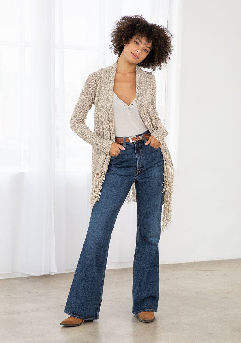 [Color: Natural/Cream] A front facing image of brunette model wearing a marled knit cardigan with a fringe hem, shawl collar, and a cozy, relaxed fit. A versatile fall cardigan. 