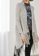 [Color: Black/Off White] A front facing image of brunette model wearing a marled knit cardigan with a fringe hem, shawl collar, and a cozy, relaxed fit. A versatile fall cardigan. 