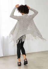 [Color: Black/Off White] A back facing image of brunette model wearing a marled knit cardigan with a fringe hem, shawl collar, and a cozy, relaxed fit. A versatile fall cardigan. 