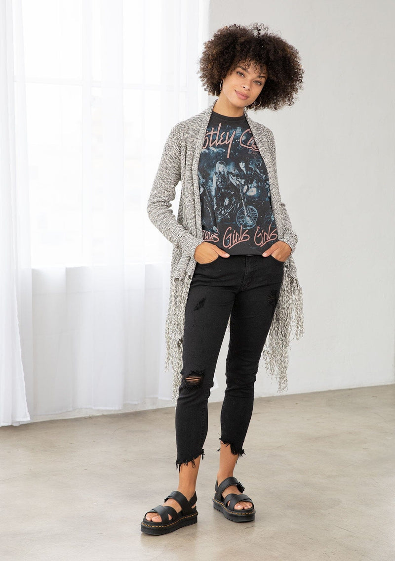 [Color: Black/Off White] A front facing image of brunette model wearing a marled knit cardigan with a fringe hem, shawl collar, and a cozy, relaxed fit. A versatile fall cardigan. 