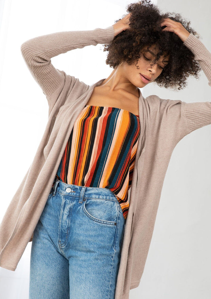 [Color: Mushroom] A front facing image of a brunette model wearing a beige cardigan with a sheer back. Featuring cozy ribbed sleeves, and open front, and shawl collar. A casual fall style for effortless layering. 