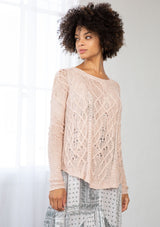 [Color: Blush] A front facing image of a brunette model wearing a lightweight cable knit pullover with open knit details. Featuring a classic round neckline, dropped shoulders, long sleeves, and a shirttail hem. Laid-back boho style for casual outings. 