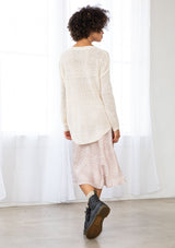 [Color: Vanilla] A back facing image of a brunette model wearing a lightweight cable knit pullover with open knit details. Featuring a classic round neckline, dropped shoulders, long sleeves, and a shirttail hem. Laid-back boho style for casual outings. 