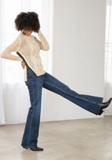 [Color: Natural] An image of a brunette model wearing a beige crochet pullover sweater with a side zipper accent. Featuring a crew neckline, long sleeves, and rib trim. 