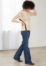 [Color: Natural] An image of a brunette model wearing a beige crochet pullover sweater with a side zipper accent. Featuring a crew neckline, long sleeves, and rib trim. 