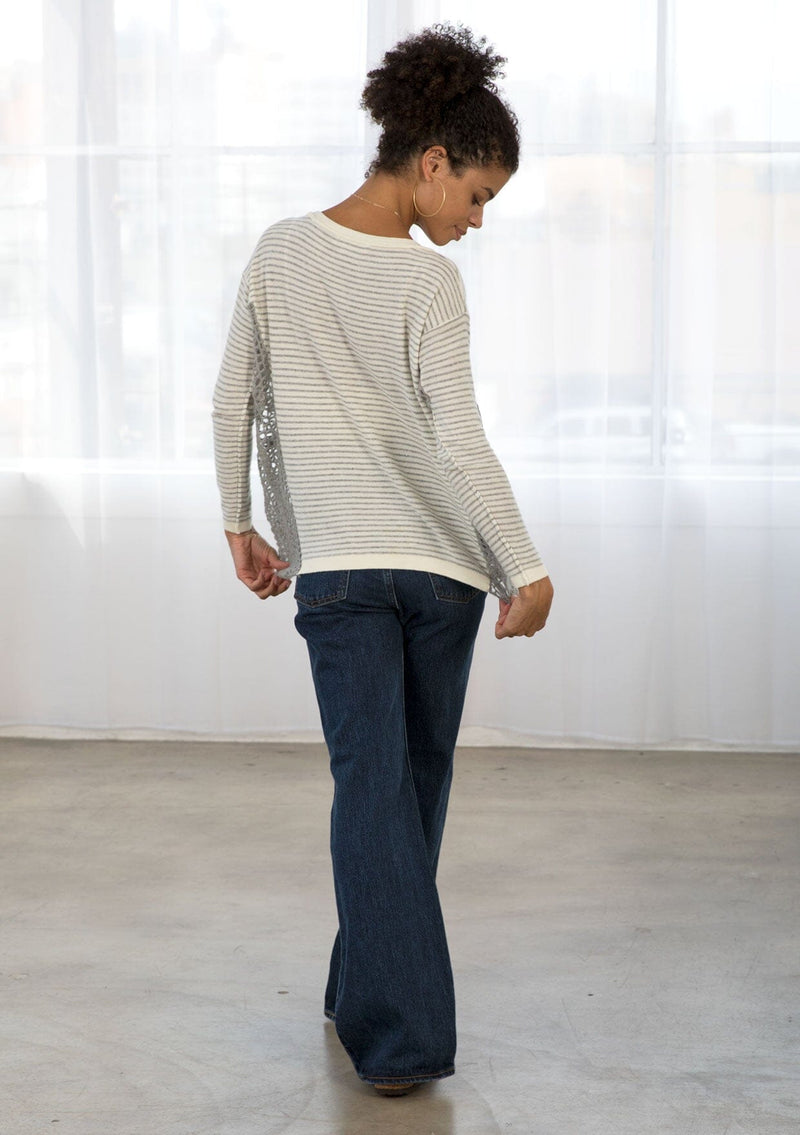 [Color: Grey/Ivory] A back facing image of brunette model wearing a boho striped pullover with a crochet accent.