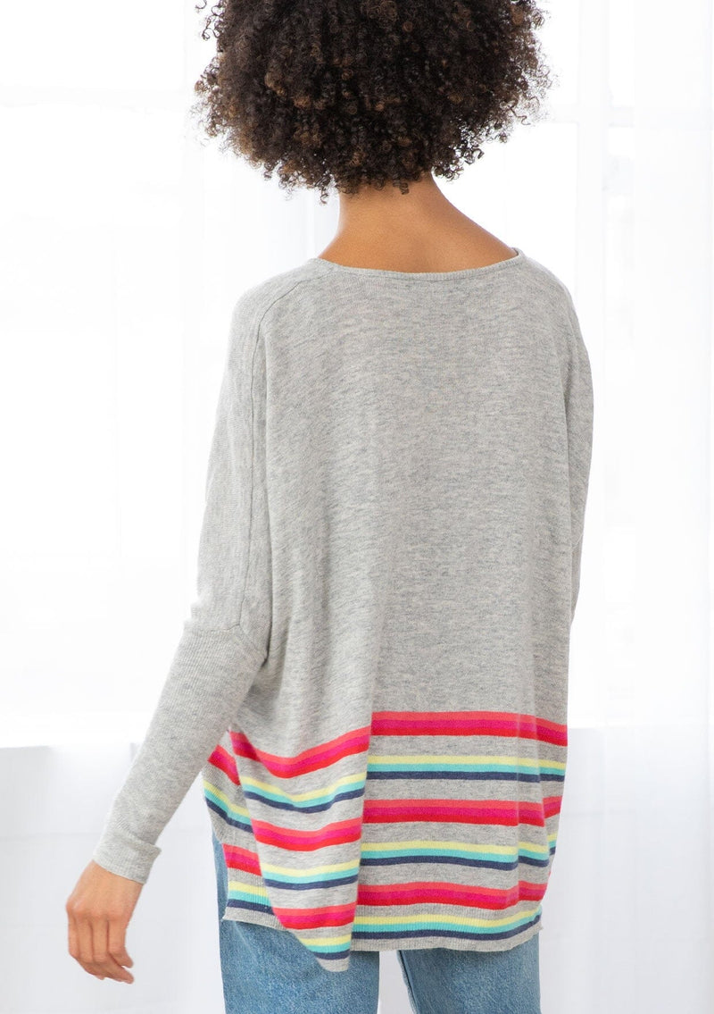 [Color: Silver/Multi] A back facing image of a brunette model wearing a grey pullover with a vibrant stripe accent. Featuring a relaxed fit, long dolman sleeves with tapered  finish, and a flattering round neckline. 